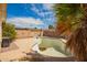 In-ground pool sitting awaiting renovation in a yard with brick features and tropical trees at 1407 W Utopia Rd, Phoenix, AZ 85027