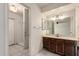 Bathroom featuring a wood vanity, large mirror, and a walk-in shower at 1407 W Utopia Rd, Phoenix, AZ 85027