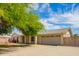 Well-maintained single-story home features a two-car garage and an arched window and landscaping at 1407 W Utopia Rd, Phoenix, AZ 85027