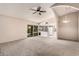 Open living room featuring carpet floors, vaulted ceilings, and sliding glass doors to the backyard at 1407 W Utopia Rd, Phoenix, AZ 85027