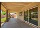A covered patio, great for outdoor seating, adjoins the house with sliding glass doors and views of the backyard at 1407 W Utopia Rd, Phoenix, AZ 85027