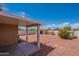 Outdoor view of a covered patio and private backyard with low-maintenance desert landscaping at 14244 N 132Nd Ln, Surprise, AZ 85379