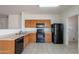 Well-equipped kitchen with black appliances and wood cabinets offers ample storage at 14244 N 132Nd Ln, Surprise, AZ 85379