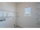 Bright laundry room with wire shelving and a window providing ample natural light at 14244 N 132Nd Ln, Surprise, AZ 85379