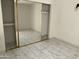 Bright bedroom with a mirrored sliding door closet and stylish tile flooring at 14300 W Bell Rd # 57, Surprise, AZ 85374