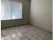 Bright bedroom with stylish tile flooring, large window, and neutral color scheme at 14300 W Bell Rd # 57, Surprise, AZ 85374