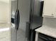A side by side black refrigerator is featured in this kitchen with gray cabinets at 14300 W Bell Rd # 57, Surprise, AZ 85374
