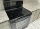 A modern electric Frigidaire stove and oven are set in a kitchen with granite countertops at 14300 W Bell Rd # 57, Surprise, AZ 85374