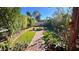 Lush backyard features an outdoor fire pit, lush landscaping, and charming brick walkway at 14605 S 35 Pl, Phoenix, AZ 85044