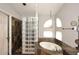 Beautiful bathroom featuring a glass block shower, soaking tub, and earth-tone tile work at 14605 S 35 Pl, Phoenix, AZ 85044