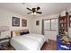 Cozy bedroom with a ceiling fan, a comfortable bed, and warm terracotta tile flooring at 14605 S 35 Pl, Phoenix, AZ 85044