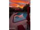 Backyard with a sparkling pool reflecting the vibrant sky at sunset at 14605 S 35 Pl, Phoenix, AZ 85044