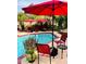 Inviting pool area with a vibrant pool, red patio umbrellas, and comfortable seating at 14605 S 35 Pl, Phoenix, AZ 85044