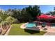 Beautiful pool area with red patio umbrellas and chairs with artificial turf at 14605 S 35 Pl, Phoenix, AZ 85044