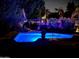 Inviting pool area at night with a vibrant pool and beautiful ambient lights at 14605 S 35 Pl, Phoenix, AZ 85044