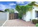 Side yard with a wooden gate, gravel ground cover, and mature climbing vines, adding privacy and charm at 14605 S 35 Pl, Phoenix, AZ 85044