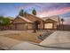 Exterior elevation featuring a well-maintained yard, 3-car garage, and inviting desert rock landscaping at 1523 E Tulsa St, Chandler, AZ 85225