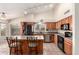 Charming kitchen featuring wood cabinets, island with seating, modern stainless steel appliances, and tile flooring at 1523 E Tulsa St, Chandler, AZ 85225