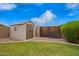 Backyard shed for extra storage, complimented by green lawn and a wooden fence for privacy at 1523 E Tulsa St, Chandler, AZ 85225