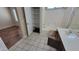 Bathroom view showcasing tile flooring, tub/shower combo, and storage shelves; a practical and clean space at 15642 N Naegel Dr, Surprise, AZ 85374