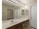 Bright bathroom with tile flooring, long vanity, and a large mirror reflecting another bathroom at 15642 N Naegel Dr, Surprise, AZ 85374