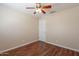 Bedroom with a ceiling fan, wood floors, neutral walls and a white door at 15642 N Naegel Dr, Surprise, AZ 85374