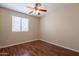 Bright bedroom with dark wood floors and a window letting in natural light at 15642 N Naegel Dr, Surprise, AZ 85374