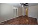 Large bedroom featuring wood floors, a ceiling fan, and easy access to the bathroom at 15642 N Naegel Dr, Surprise, AZ 85374