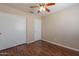 Bedroom featuring a ceiling fan, wood floors and a double door closet at 15642 N Naegel Dr, Surprise, AZ 85374