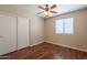 Bedroom featuring a ceiling fan, wood floors and a double door closet at 15642 N Naegel Dr, Surprise, AZ 85374