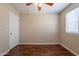 Bedroom with a ceiling fan, wood floors, neutral walls and a white door at 15642 N Naegel Dr, Surprise, AZ 85374