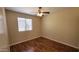 Cozy bedroom featuring hardwood floors, a ceiling fan, and natural light at 15642 N Naegel Dr, Surprise, AZ 85374