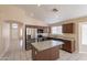 Updated kitchen with stainless steel appliances, granite counters, island, and tiled floors at 15642 N Naegel Dr, Surprise, AZ 85374