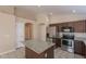 Well-lit kitchen with granite countertops, tile floors, stainless appliances, and center island at 15642 N Naegel Dr, Surprise, AZ 85374