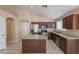 Modern kitchen featuring granite countertops, stainless steel appliances, an island, and tiled floors at 15642 N Naegel Dr, Surprise, AZ 85374