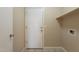 Laundry room with a white door, tile floors, and a utility shelf at 15642 N Naegel Dr, Surprise, AZ 85374