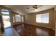 Bright living room featuring wood floors, large windows, and a ceiling fan at 15642 N Naegel Dr, Surprise, AZ 85374