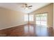 Spacious living room with vaulted ceiling, ceiling fan, wood floors, and sliding glass doors to the backyard at 15642 N Naegel Dr, Surprise, AZ 85374