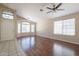 Bright living room with wood floors, ceiling fan, and multiple windows with natural light at 15642 N Naegel Dr, Surprise, AZ 85374