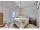 Cozy bedroom with neutral walls and plush bedding, featuring a ceiling fan and natural light at 16230 E Glenpoint Dr, Fountain Hills, AZ 85268