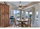 Cozy dining area featuring a round wood table, ceiling fan, and large windows with a backyard view at 16230 E Glenpoint Dr, Fountain Hills, AZ 85268