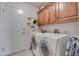 Inside laundry room with tiled floor and overhead cabinets for storage in a neutral tone at 16230 E Glenpoint Dr, Fountain Hills, AZ 85268