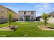 A spacious, grassy backyard with young trees and a covered patio at 16956 W Alice Ave, Waddell, AZ 85355