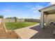 Spacious backyard with lush lawn, young trees, and a covered patio area at 16956 W Alice Ave, Waddell, AZ 85355