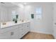 Modern bathroom with double vanity, white cabinets, and beautiful wood-look floors at 16956 W Alice Ave, Waddell, AZ 85355