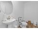 Bright bathroom with round mirror, white vessel sink and beige tile flooring at 16956 W Alice Ave, Waddell, AZ 85355