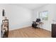 Minimalist bedroom featuring hard wood floors and light, neutral colored walls at 16956 W Alice Ave, Waddell, AZ 85355