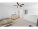 Bedroom with ceiling fan, carpet flooring, dresser and white door leading to a hallway at 16956 W Alice Ave, Waddell, AZ 85355