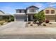 Two-story home featuring drought-tolerant landscaping, a two-car garage and neutral color palette at 16956 W Alice Ave, Waddell, AZ 85355