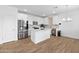 Kitchen featuring white cabinets, center island, stainless steel appliances and wood-look floors at 16956 W Alice Ave, Waddell, AZ 85355